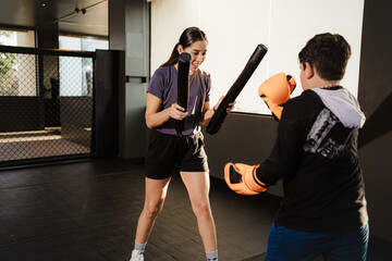 Wall Mural - female boxing coach training a boy in gym