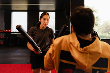 Wall Mural - female boxing coach training a boy in gym