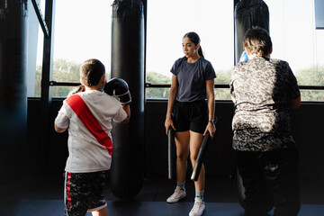 Wall Mural - female kick boxing coach training children in gym