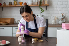 Female Pastry Chef Covers Chocolate Bear Figurine With Gold With Brush. Selective Focus. Image For Articles About Confectionery.