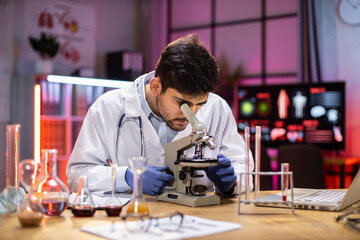 Wall Mural - Young indian male researcher looking at the microscope analyze science, forensics, microbiology, biochemistry, genetics, oncology, laboratory.