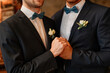 © Seventyfour - Close up of male gay couple holding hands during wedding ceremony, same sex marriage