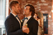 © Seventyfour - Waist up portrait of young gay couple dancing together during wedding ceremony, copy space