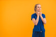 © PoppyPix - Female doctor in blue using a Stethoscope and looking at the camera - closeup orange background. High quality photo
