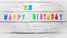 Top View Of Happy Birthday Candle Numbers Copy Space On Wooden White Pastel Boards. Beautiful Birthday Card With Number 33