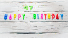 Top View Of Happy Birthday Candle Numbers Copy Space On Wooden White Pastel Boards. Beautiful Birthday Card With Number 47