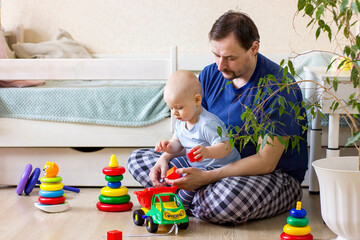 Father and baby boy playing together with toys.