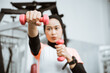 © Odua Images - Asian muslim woman doing exercise, lifting dumbbell at the gym