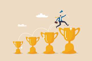 Wall Mural - Small win or achievement to motivate to achieve bigger goal, strategy or inspiration to success, victory or win award concept, confident businessman jumping from small win trophy to get bigger one.