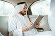 © Odua Images - muslim asian man wearing turban using a pad while sitting on his car