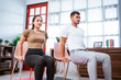 © Odua Images - modern young asian couple exercising at home using chair to help them workout