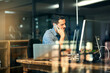 © Jadon Bester/peopleimages.com - Hes not afraid of hard work. Shot of a young businessman talking on his phone and using a computer during a late night at work.
