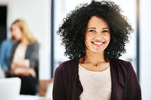 Closeup Portrait Of A Happy, Successful And Confident Business Woman Standing In A Office. Beautiful African American Female Smiling, With Her Colleagues In The Blurred Copyspace Background.