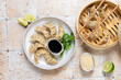 Dumplings gyoza jiaozi steamed  on a white plate with soy sauce. Takeout  food