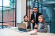 © Odua Images - business team showing thumb up while sitting at the office. muslim people worker smiling to camera