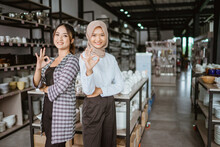 Two Beautiful Asian Women Standing Back To Back With Okay Hand Gesture In Glassware Store