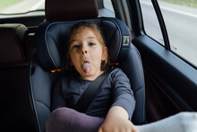 Adorable Calm Child Sticking Tongue Out In Car During Trip