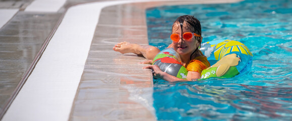 Cute young girl in the swimming pool. Summer holiday, adventure and happy childhood concept. Copy space for design or text.