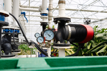 Wall Mural - Pipelines and pumps for heating and irrigation in a modern greenhouse