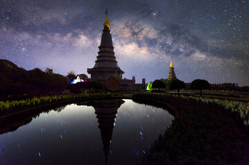 Wall Mural - the milky way galaxy moving over a sacred temple at doi inthanon national park, chiang mai, thailand