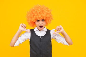 Wall Mural - Birthday kids party. Funny kid in curly clown wig isolated on yellow background. Angry teenager girl, upset and unhappy negative emotion.