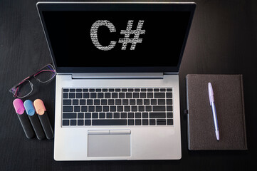 Laptop with C# text. Top view. C sharp inscription on laptop screen.