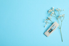 Stylish Hair Clip And Flowers On Light Blue Background, Flat Lay. Space For Text