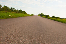 The  Asphalt Road Leading Through The Countryside Environment With Natural Scenery Of Forest And Agricultural Fields.