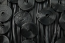 Tasty Black Liquorice Candies As Background, Top View