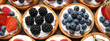Delicious tartlets with fresh berries, top view. Banner design