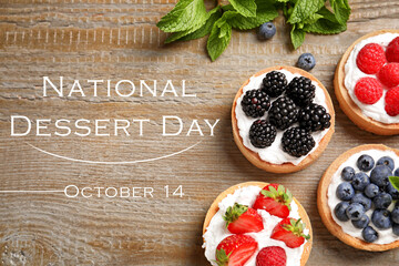 Sticker - National Dessert Day, October 14. Tasty tartlets with different fresh berries on wooden table, flat lay