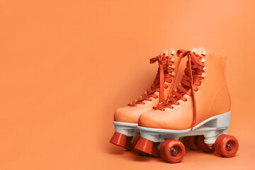 Wall Mural - pair of stylish quad roller skates on orange background. space for text