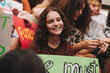 © Jacob Lund - Happy teenage girl sitting with a crowd of climate change activists