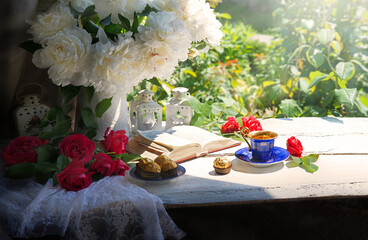 Wall Mural - Bible and a bouquet of peonies on a table in the garden