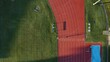 Aerial 4K Drone View Of Fit Athlete Running Fast Laps On Outdoor Red Race Track