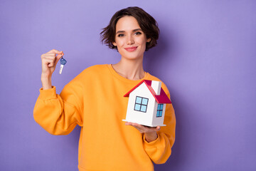 Sticker - Portrait of pretty glad person hold demonstrate small house key isolated on purple color background