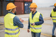© DisobeyArt - Workers controlling shipping containers at industrial port outdoor - Focus on right man face