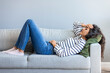 © Dragana Gordic - Full length young woman lying on sofa suffers from heartache cover face with hands crying feels desperate unhappy unwell having mental pain or serious health problems, beak up divorce abortion concept
