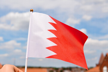 Wall Mural - close up of national flag of bahrain on blue sky background ,red and white color