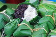 Thai steamed black and white sticky rice wrapped in banana leaf package.