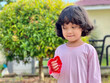 © Arief Nurhidayanto - Portrait of a little girl wearing pink dress and smiling with background of green leaves