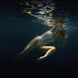 © Dmitry - A woman in a white swimsuit underwater as if in weightlessness