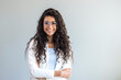 © Dragana Gordic - Portrait of young smiling woman looking at camera with crossed arms. Happy girl standing in creative office. Successful businesswoman standing in office with copy space.