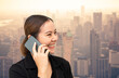 © littlestocker - Asian businesswoman talking on mobile phone with cityscape on background