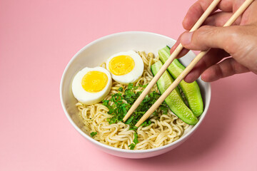 Sticker - Portion of noodles with a boiled egg on a pink background. Traditional oriental food. instant noodles