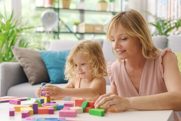 Wall Mural - Happy woman playing with her daughter at home