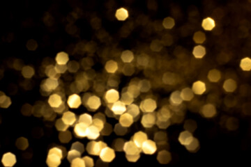 Golden blurred bokeh lights on black background. Glitter sparkle stars for celebrate. Overlay for your design