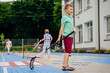 © Iryna - Preteen boy hockey player hitting ball with hockey stick on the playground outdoor. Summer activites for children concept.