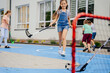 © Iryna - Children playing street hockey on a city holiday on the playground. Happy kids group have fun. Summer activites for children concept.