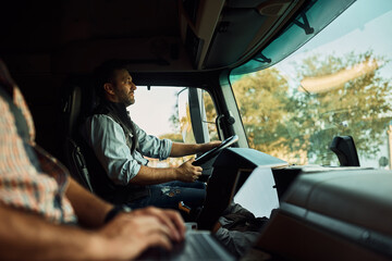 Wall Mural - Professional driver and his colleague driving truck.